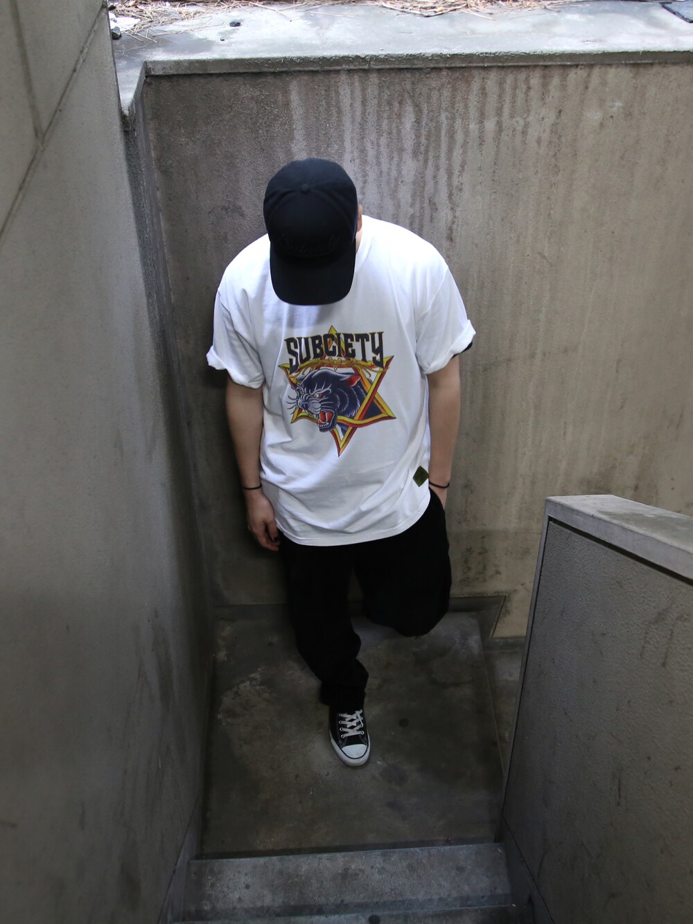 ホワイト系のTシャツ/カットソー、ブラック系のその他パンツを着用したメンズの春コーディネートの1枚目の写真