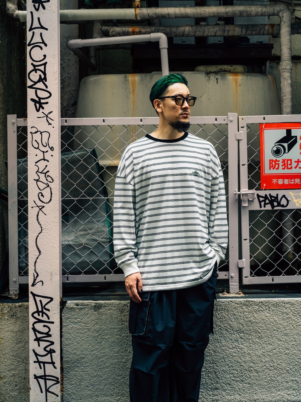 ブラック系のカーゴパンツ、ホワイト系のTシャツ/カットソーを着用したメンズの夏コーディネートの1枚目の写真