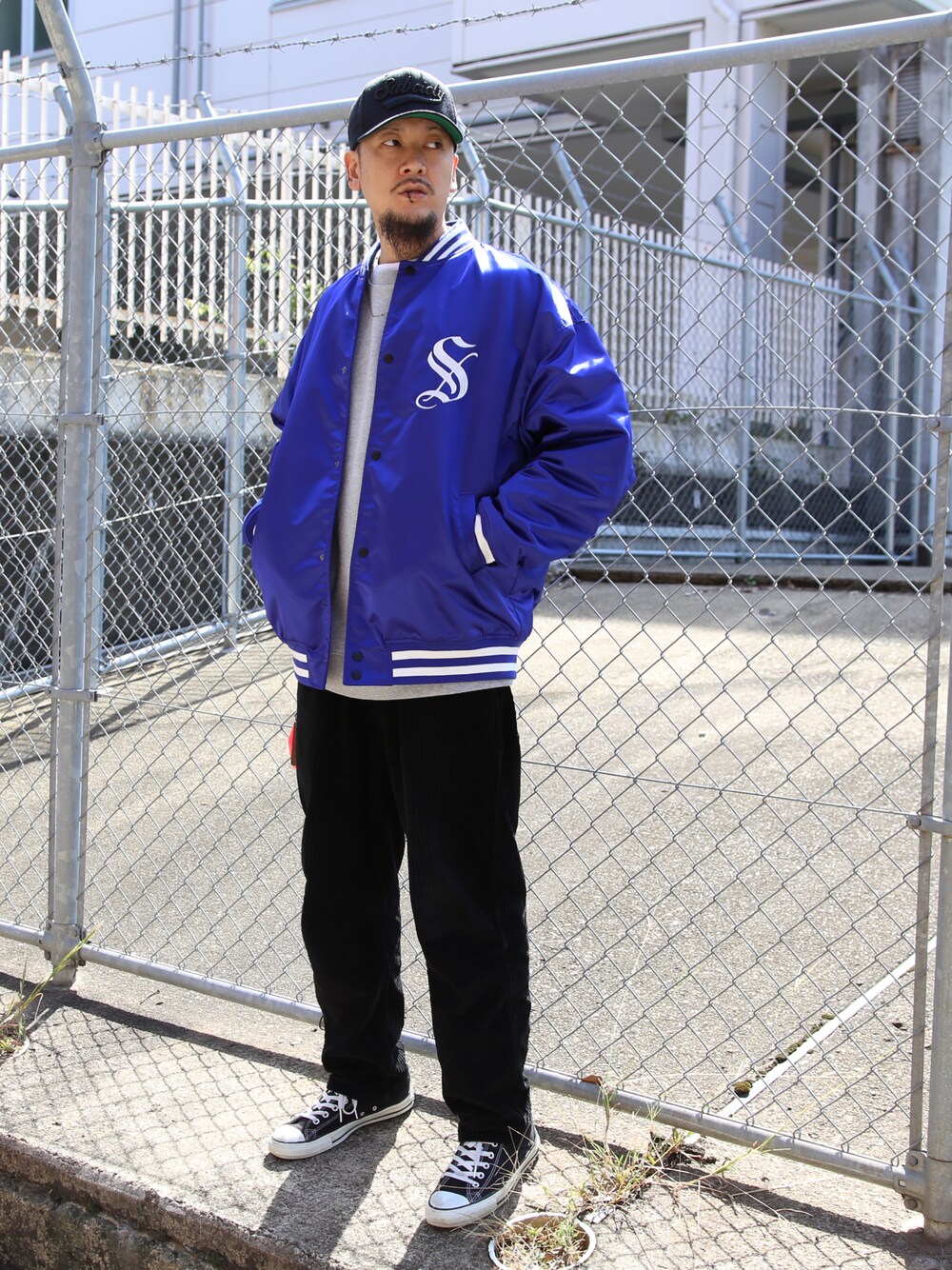 ブラック系のスラックス、ブルー系のスタジャンを着用したメンズの秋コーディネートの1枚目の写真