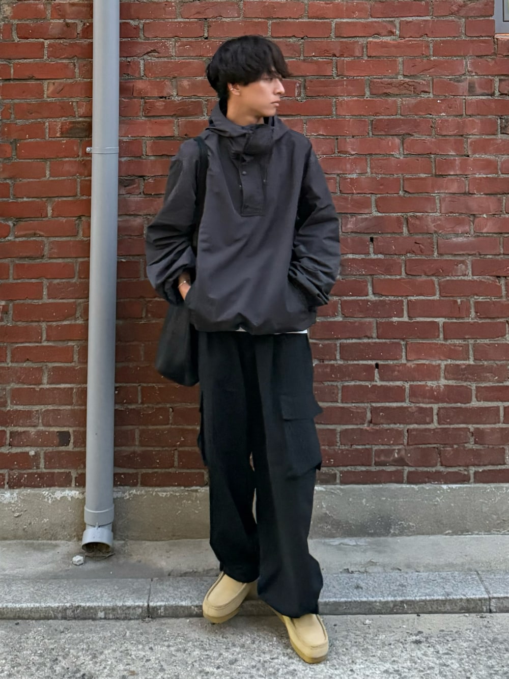 グレー系のパーカー、ブラック系のカーゴパンツ、ベージュ系のモカシン/デッキシューズを着用したメンズの秋コーディネートの1枚目の写真