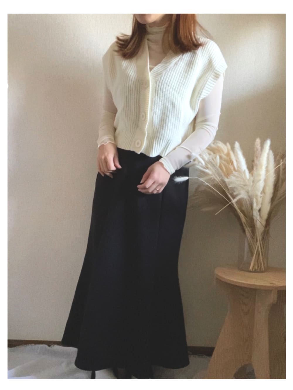 ホワイト系のベスト、ホワイト系のTシャツ/カットソー、ブラック系のスカートを着用したレディースの春コーディネートの1枚目の写真