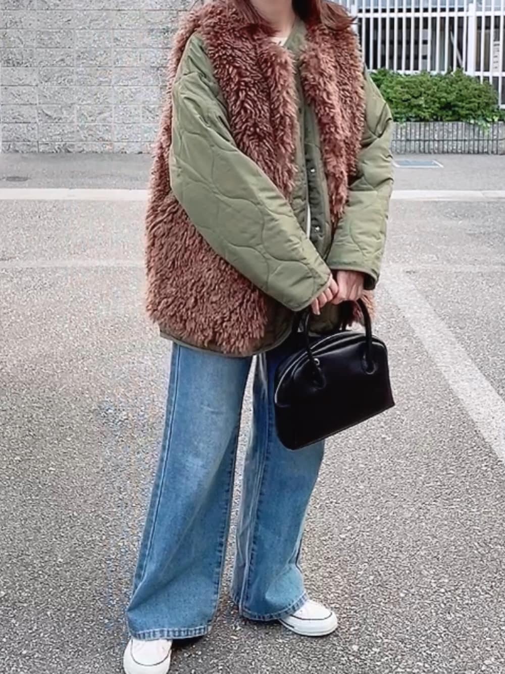 グリーン系のブルゾン、ブラック系のショルダーバッグ、ブルー系のデニムパンツを着用したレディースの秋コーディネートの1枚目の写真