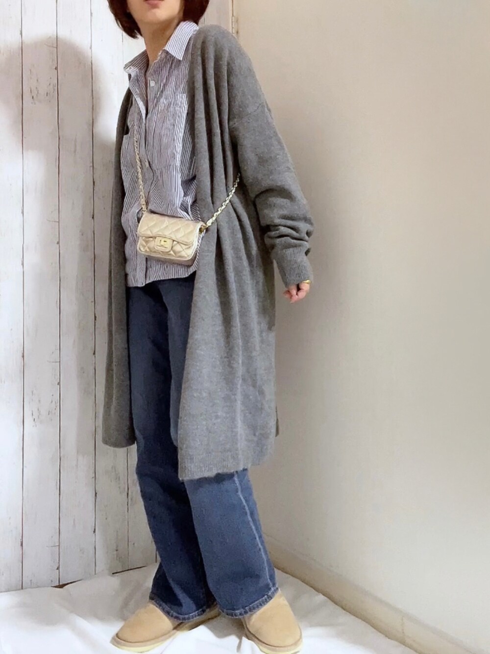 グレー系のカーディガン/ボレロ、ブルー系のパンツ、ベージュ系のその他シューズを着用したレディースの冬コーディネートの1枚目の写真