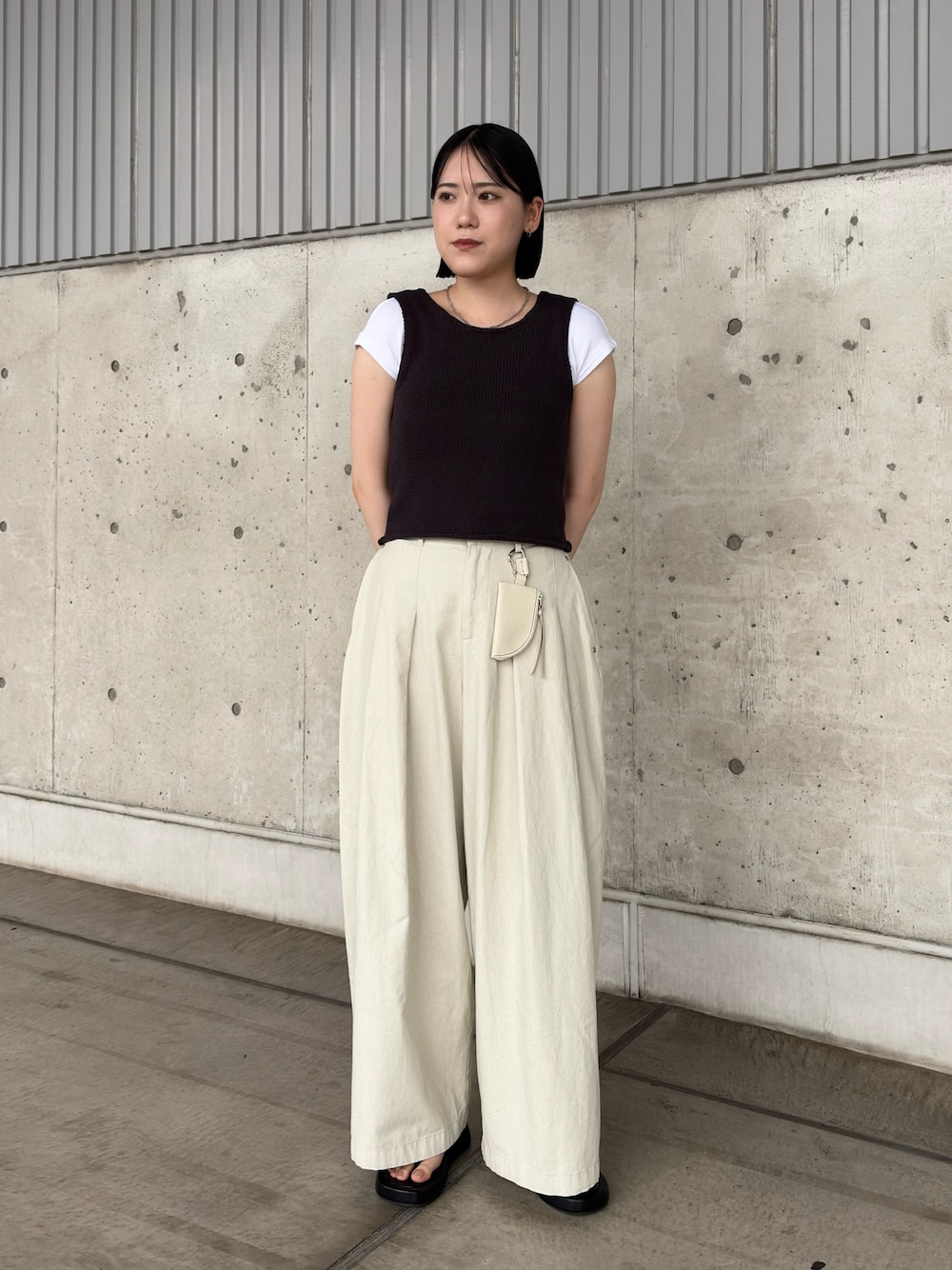グレー系のベスト、ホワイト系のその他パンツ、ブラック系のサンダルを着用したレディースの夏コーディネートの1枚目の写真