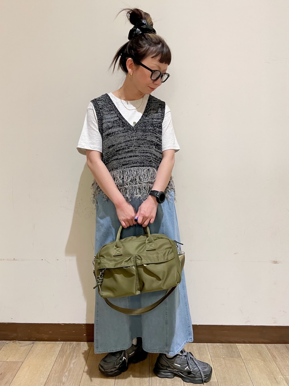 グレー系のTシャツ/カットソー、ブラック系のベスト、グリーン系のショルダーバッグを着用したレディースの夏コーディネートの1枚目の写真
