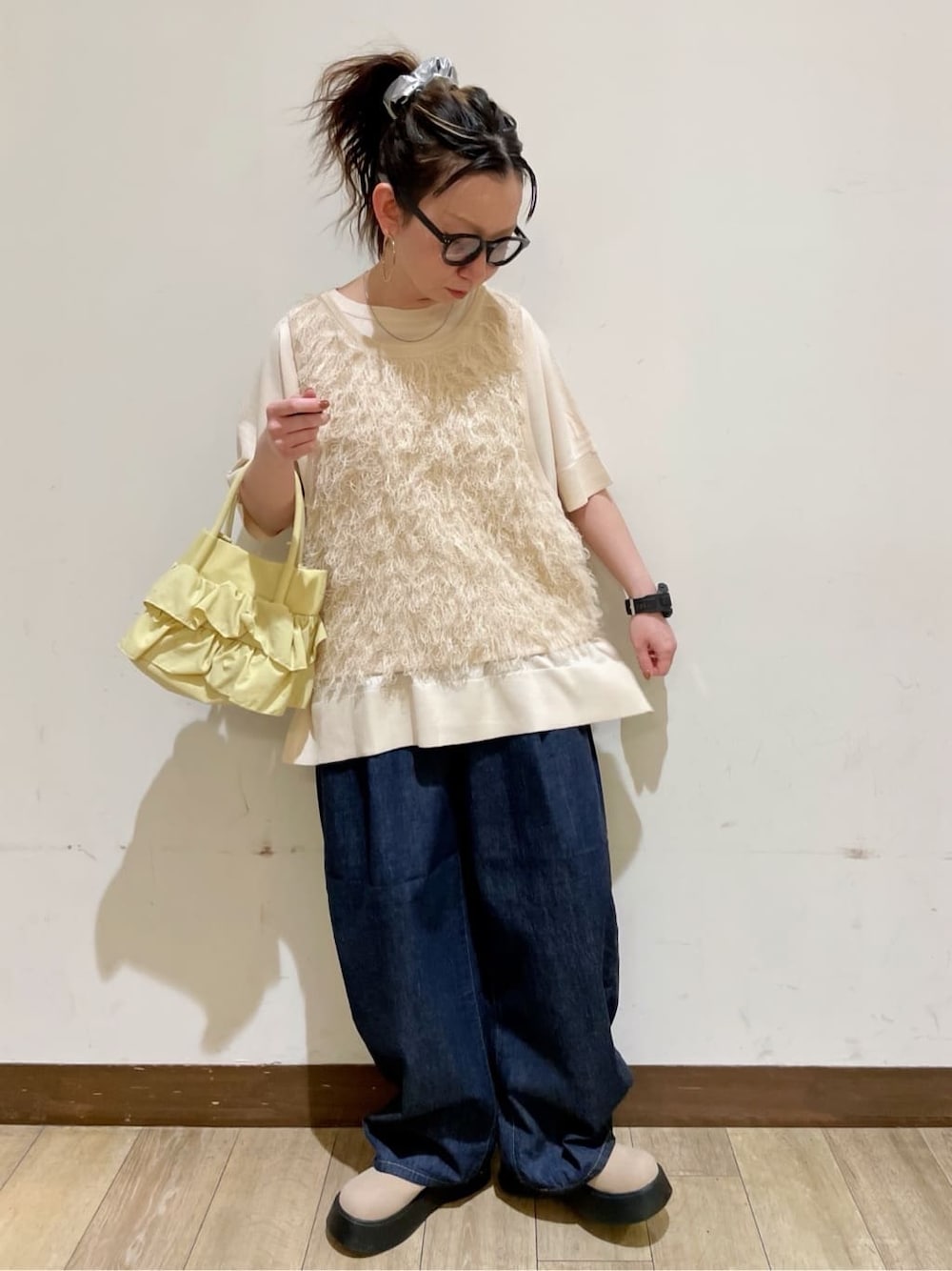 ホワイト系のベスト、ホワイト系のニット/セーター、ブルー系のデニムパンツを着用したレディースの春コーディネートの1枚目の写真