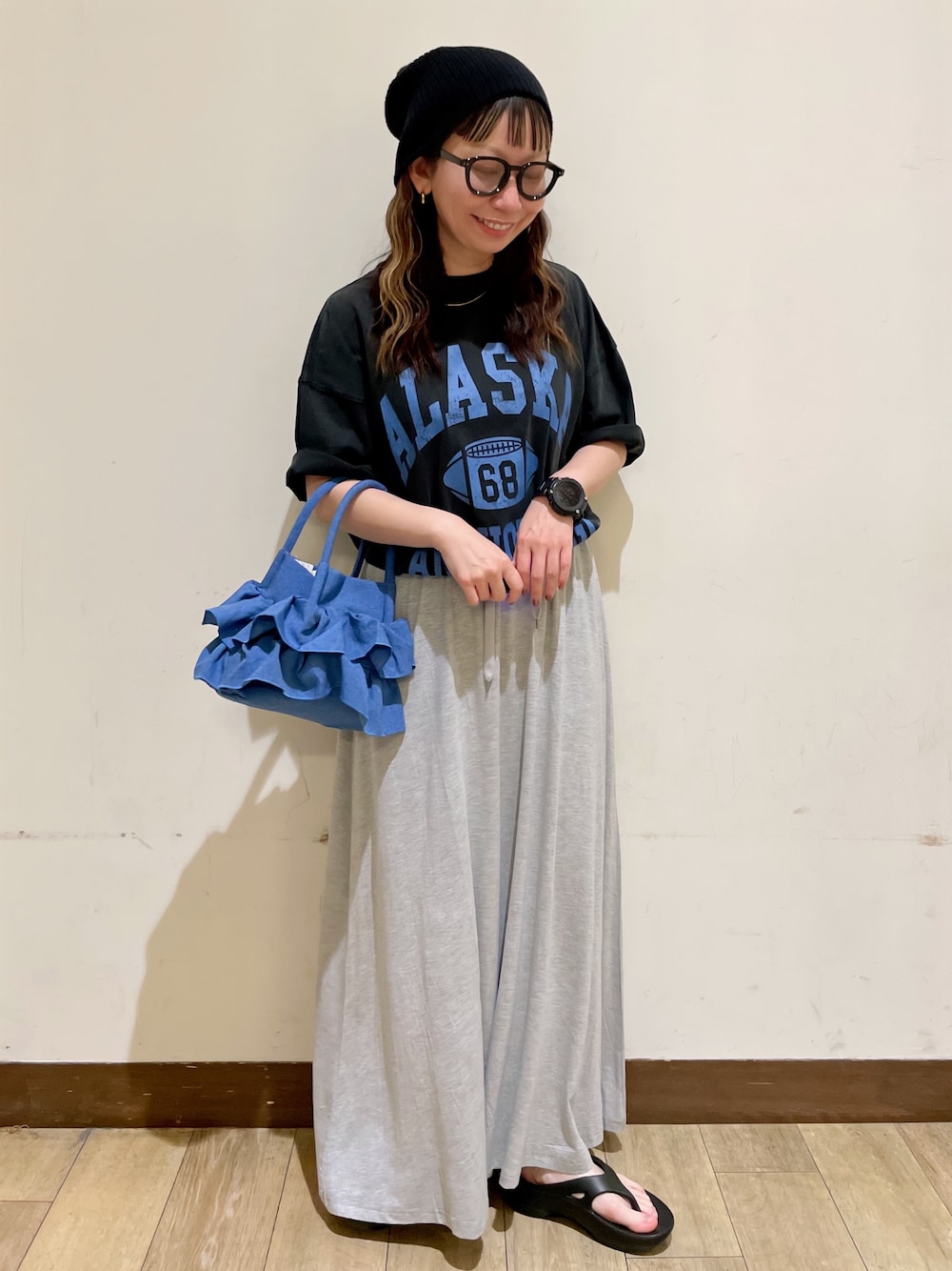 グレー系のTシャツ/カットソー、グレー系のスカート、ブラック系のサンダルを着用したレディースの夏コーディネートの1枚目の写真