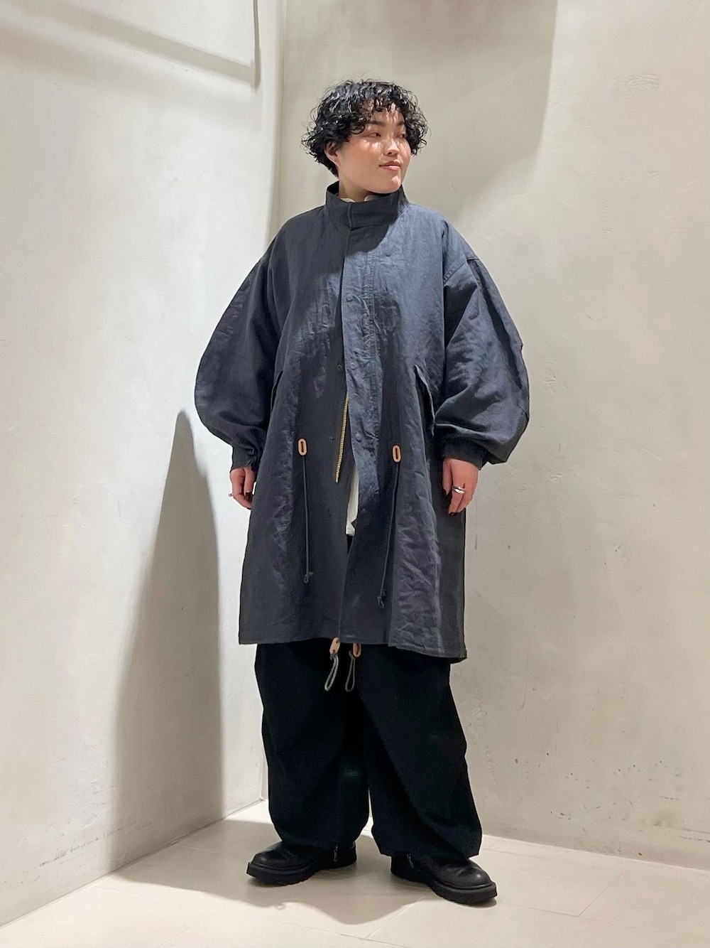 ブラック系のカーゴパンツ、ホワイト系のシャツ/ブラウス、ブラック系のニット/セーターを着用したレディースの冬コーディネートの1枚目の写真