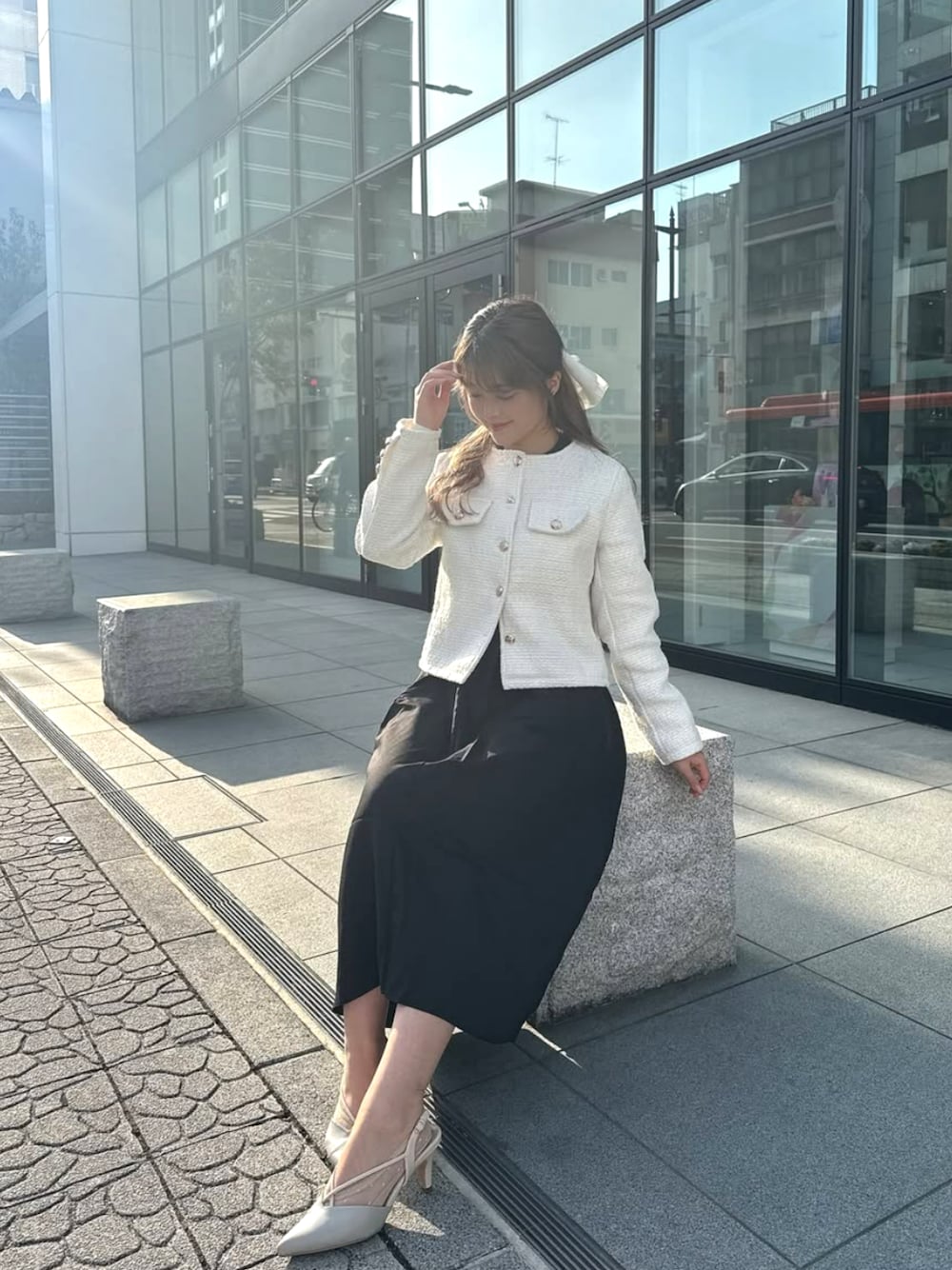 ホワイト系のノーカラージャケットを着用したレディースの冬コーディネートの1枚目の写真