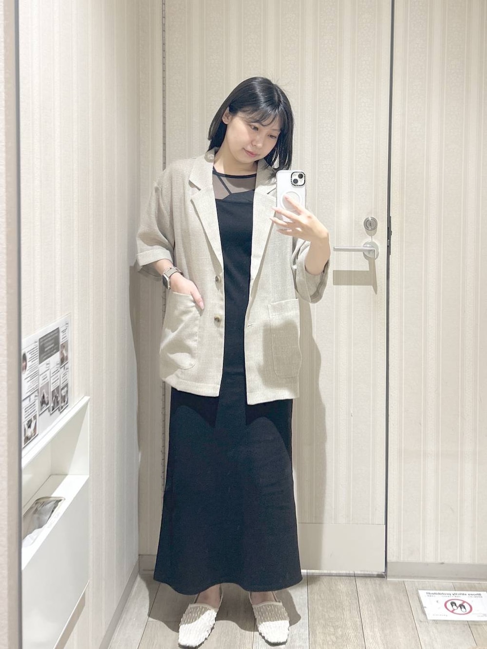 ホワイト系のパンプス、ベージュ系のテーラードジャケット、ブラック系のワンピースを着用したレディースの春コーディネートの1枚目の写真