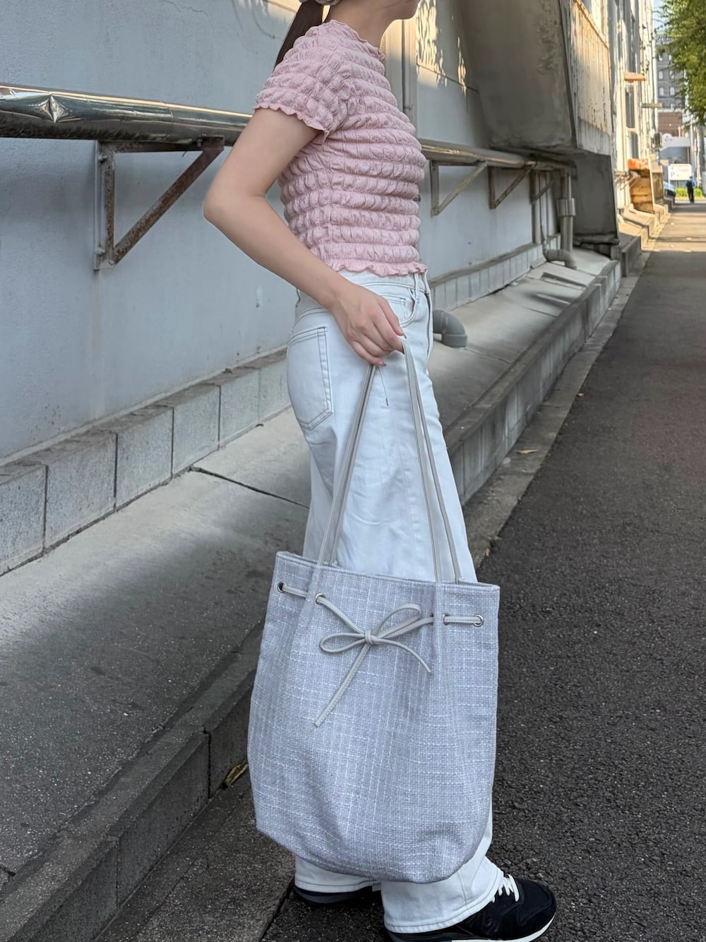 グレー系のトートバッグを着用したレディースの夏コーディネートの1枚目の写真