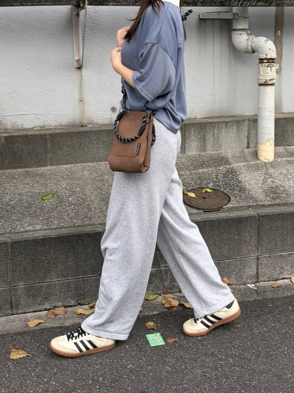 ブラウン系のショルダーバッグを着用したレディースの秋コーディネートの1枚目の写真