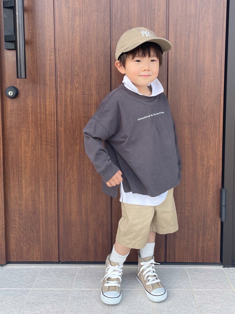 グレー系のTシャツ/カットソー、ホワイト系のトップス、ベージュ系のパンツを着用したキッズの春コーディネートの1枚目の写真