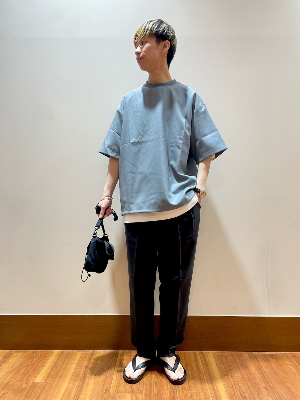 グレー系のTシャツ/カットソー、ブラック系のショルダーバッグ、グレー系のスラックスを着用したメンズの夏コーディネートの1枚目の写真