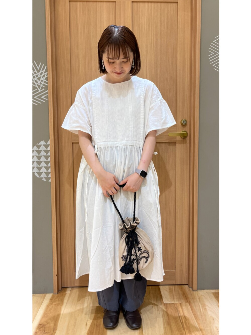 ブラウン系のその他シューズ、ブルー系のその他パンツ、ホワイト系のハンドバッグを着用したレディースの夏コーディネートの1枚目の写真