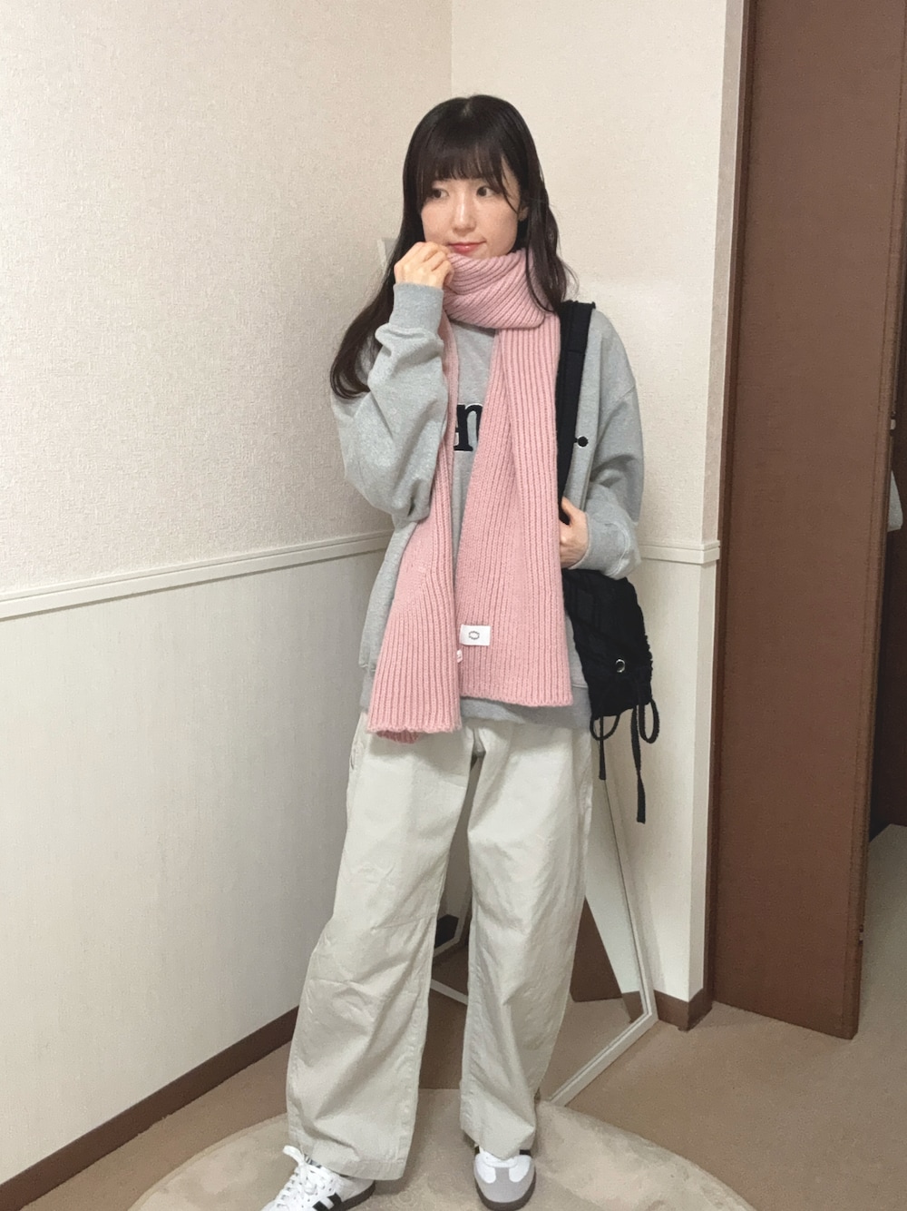 ホワイト系のパンツ、ブラック系のショルダーバッグ、ホワイト系のスニーカーを着用したレディースの秋コーディネートの1枚目の写真