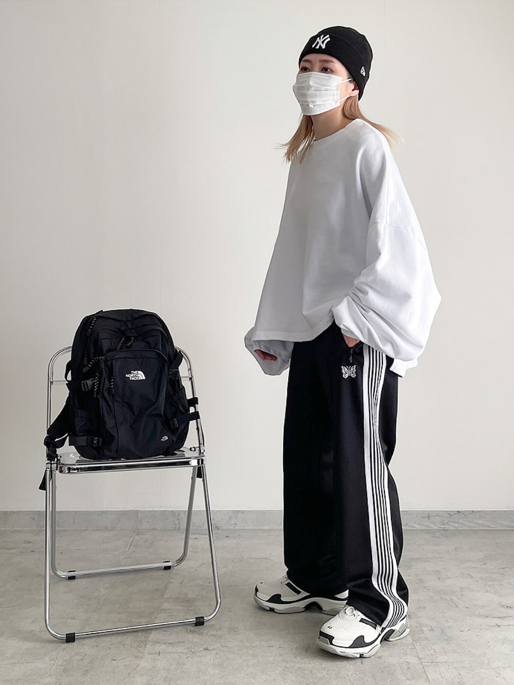 ホワイト系のスウェット、ブラック系のパンツ、ホワイト系のスニーカーを着用したレディースの冬コーディネートの1枚目の写真