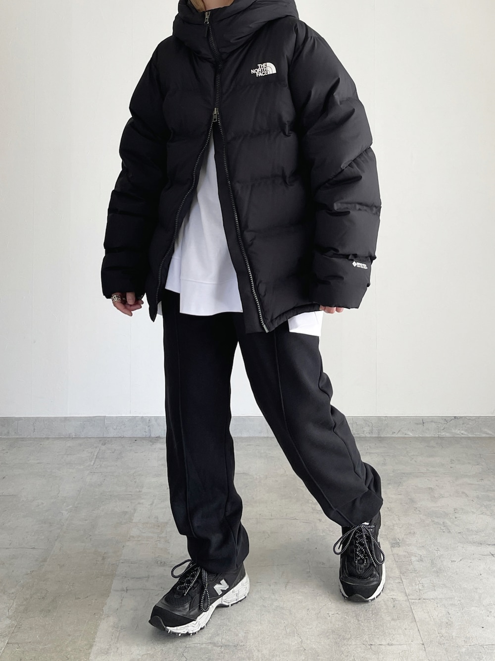 ブラック系のダウンジャケット/コート、ブラック系のスウェットパンツ、ブラック系のスニーカーを着用したレディースの冬コーディネートの1枚目の写真