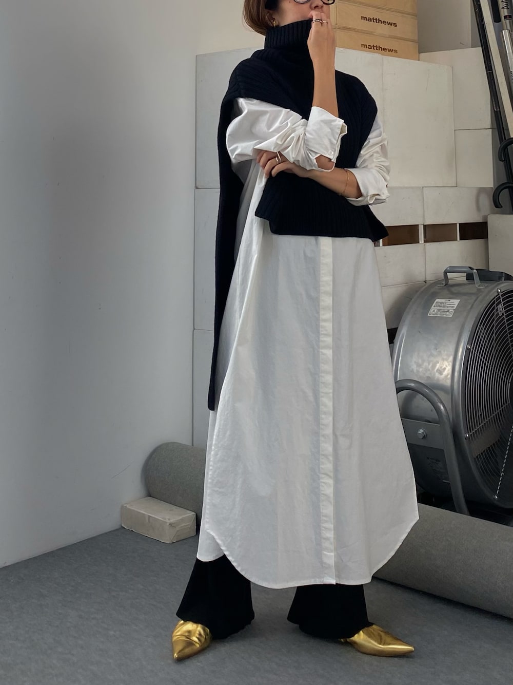 ホワイト系のシャツワンピース、ブラック系のベスト、ゴールド系のシューズを着用したレディースの秋コーディネートの1枚目の写真