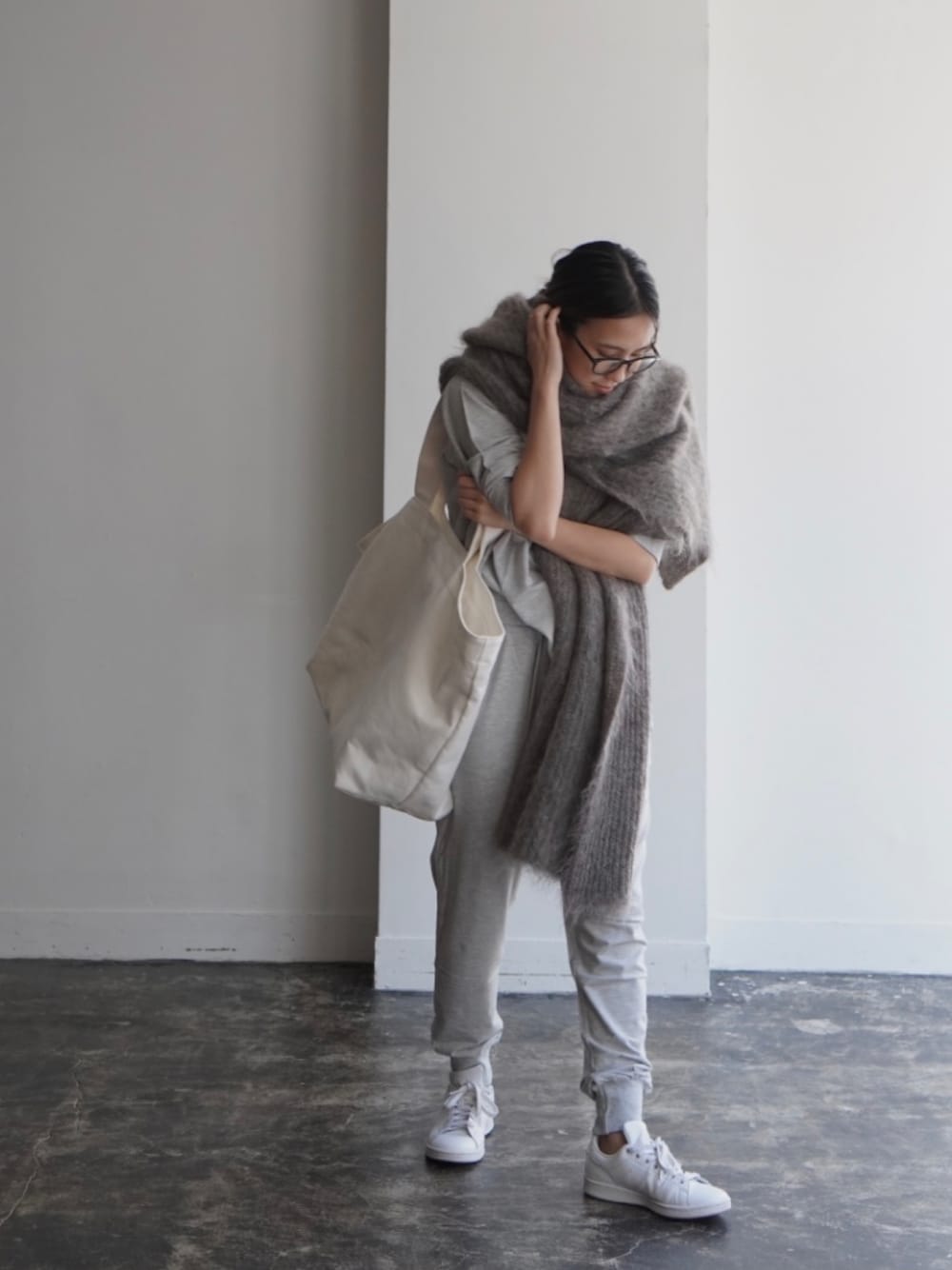 ホワイト系のトートバッグ、グレー系のニット/セーター、ホワイト系のスニーカーを着用したレディースの冬コーディネートの1枚目の写真