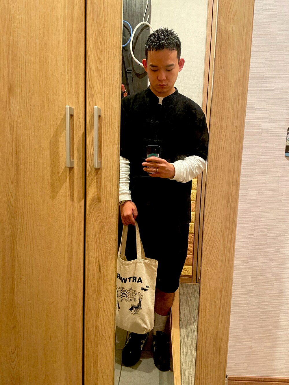 ブラック系のその他トップス、ホワイト系のTシャツ/カットソー、ベージュ系のトートバッグを着用したメンズの秋コーディネートの1枚目の写真