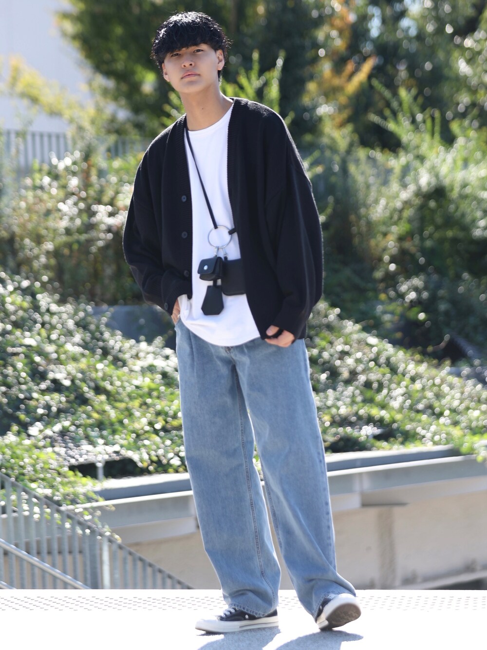 ブルー系のデニムパンツ、ブラック系のカーディガン/ボレロ、ブラック系のショルダーバッグを着用したメンズの秋コーディネートの1枚目の写真