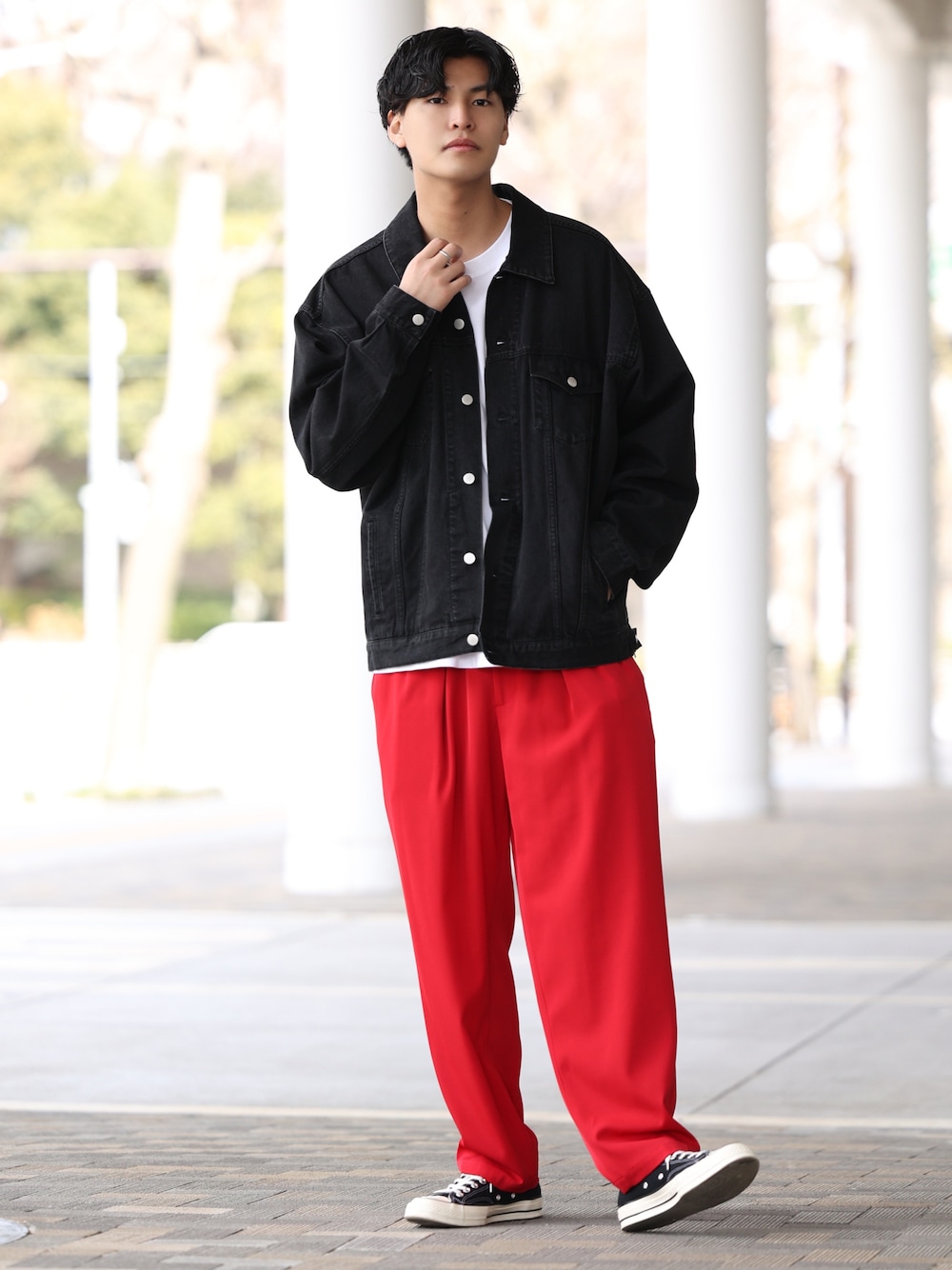 ブラック系のデニムジャケット、レッド系のその他パンツ、ブラック系のスニーカーを着用したメンズの春コーディネートの1枚目の写真