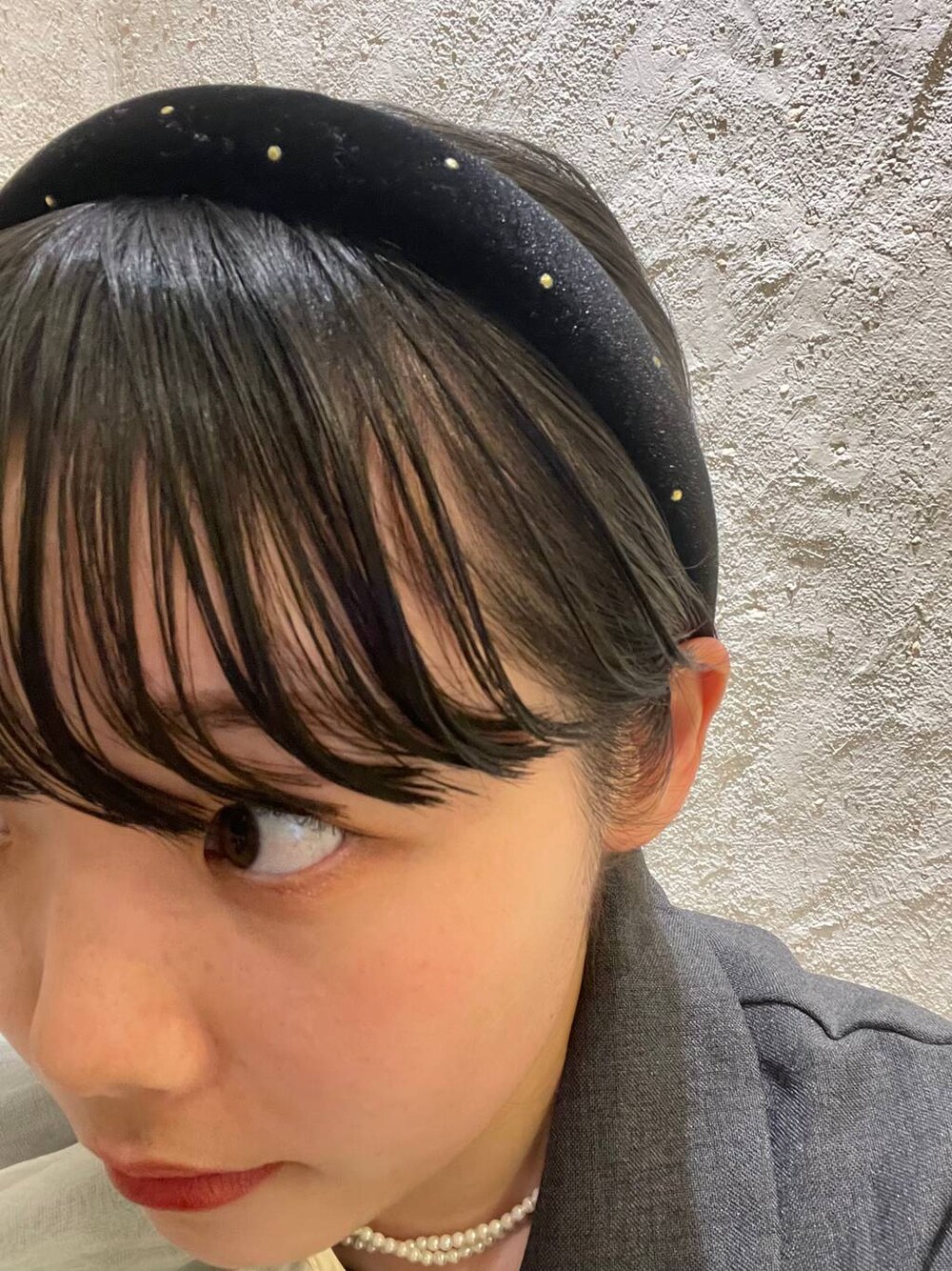 ブラック系のカチューシャを着用したレディースの春コーディネートの1枚目の写真