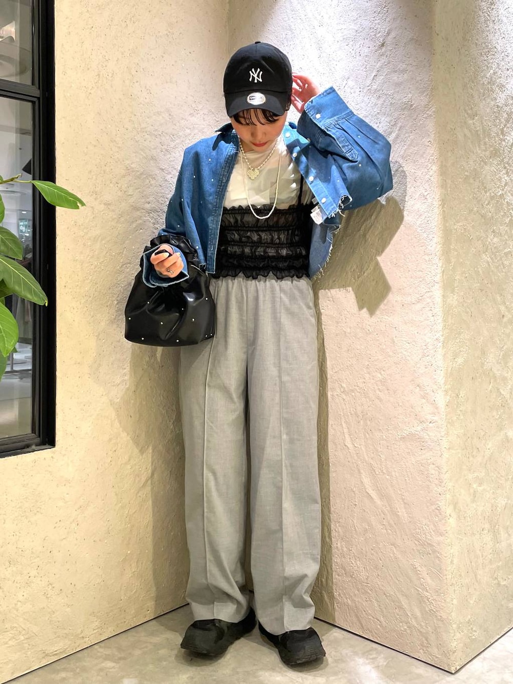 ブラック系のハンドバッグ、ブラック系のTシャツ/カットソー、ブルー系のシャツ/ブラウスを着用したレディースの春コーディネートの1枚目の写真