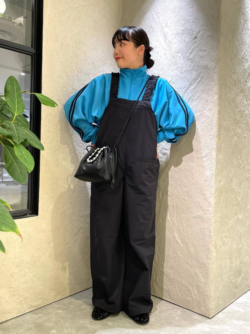 ブラック系のショルダーバッグ、ブルー系のサロペット/オーバーオール、ブルー系のTシャツ/カットソーを着用したレディースの春コーディネートの1枚目の写真