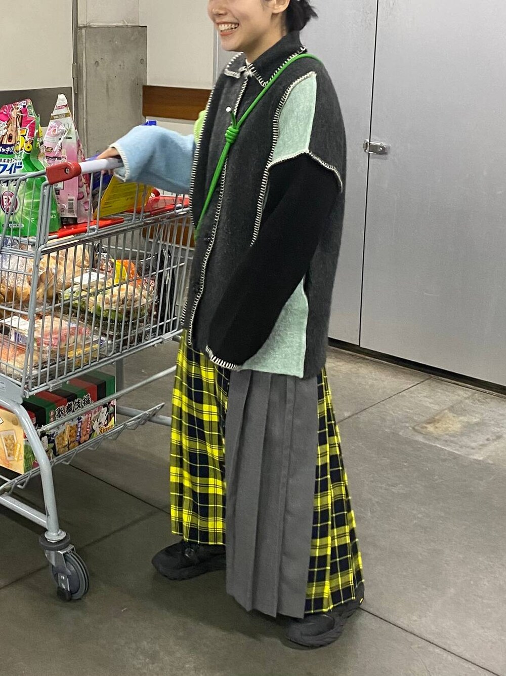 イエロー系のスカート、その他のカーディガン/ボレロ、グレー系のヘアゴムを着用したレディースの冬コーディネートの1枚目の写真