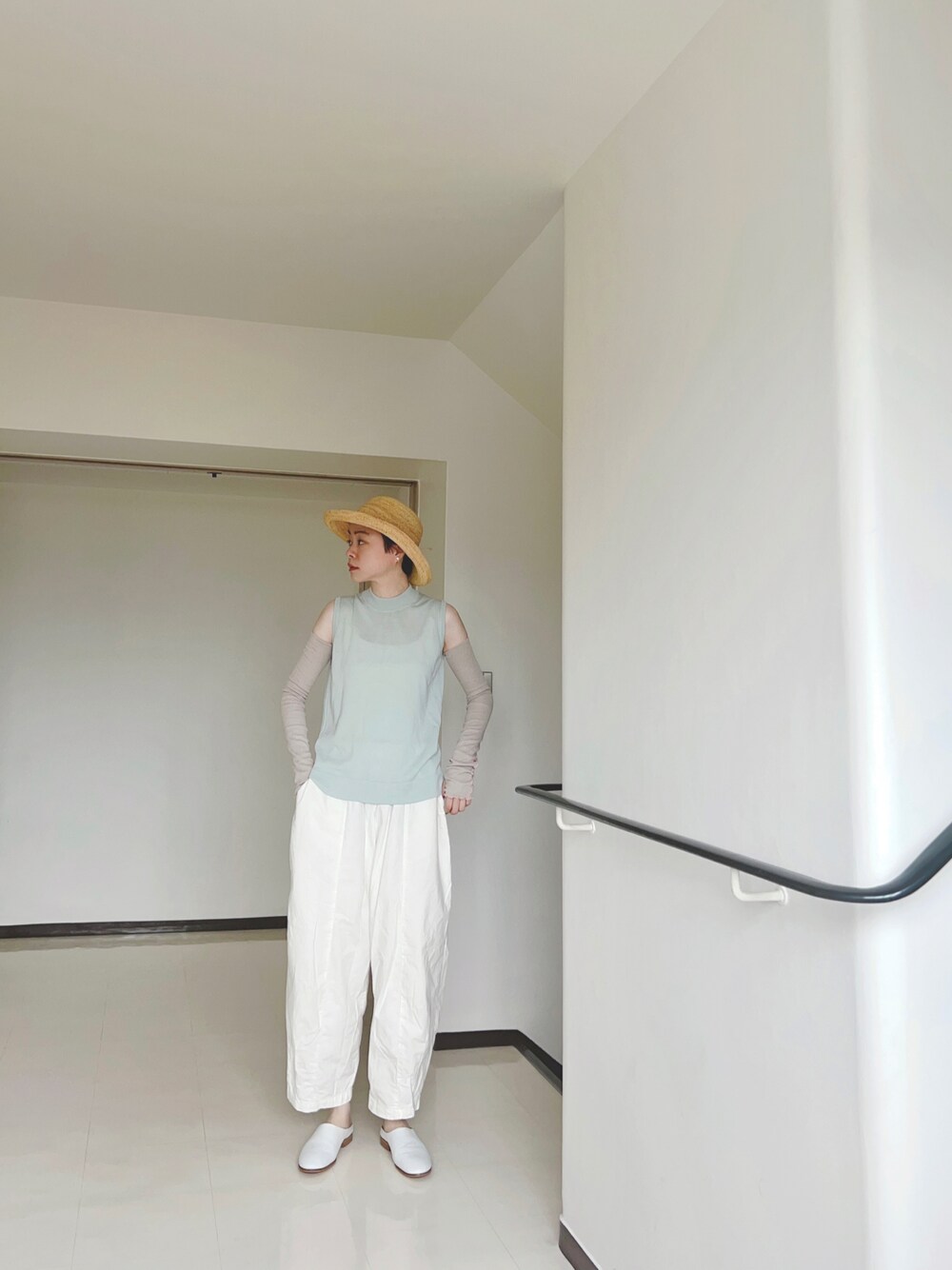 ホワイト系のシューズ、ベージュ系のハット、シルバー系のイヤーカフを着用したレディースの夏コーディネートの1枚目の写真