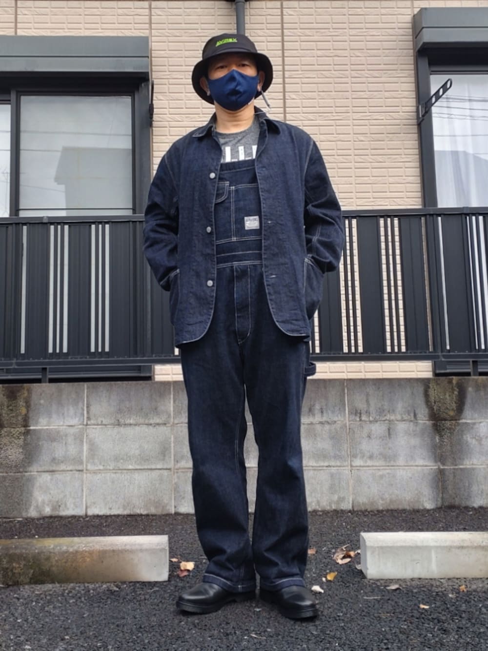 ブルー系のサロペット/オーバーオール、ブルー系のカバーオール、ブラック系のブーツを着用したメンズの秋コーディネートの1枚目の写真