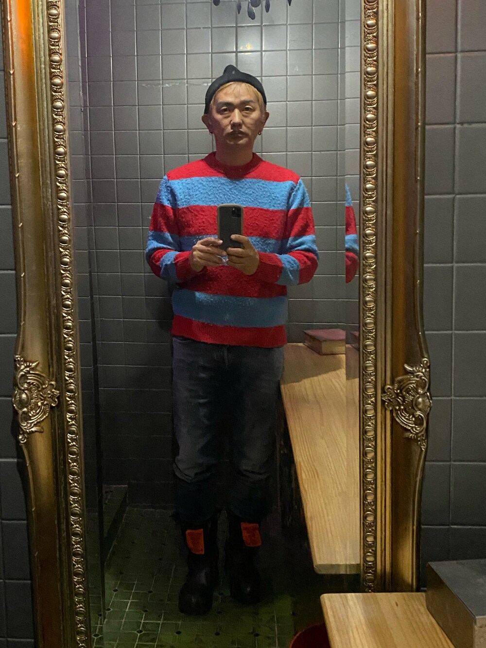 ブルー系のデニムパンツ、ブラック系のブーツ、その他のニット/セーターを着用したメンズの秋コーディネートの1枚目の写真