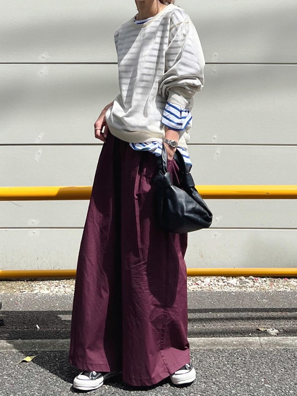 レッド系のその他パンツ、ブラック系のバッグ、グリーン系のスニーカーを着用したレディースの春コーディネートの1枚目の写真