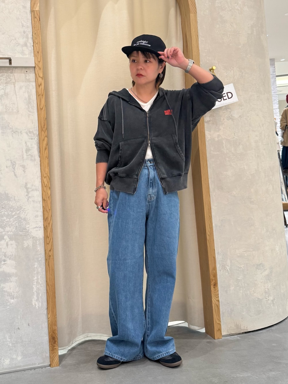 ブルー系のデニムパンツ、ホワイト系のタンクトップ、ブラック系のパーカーを着用したレディースの秋コーディネートの1枚目の写真