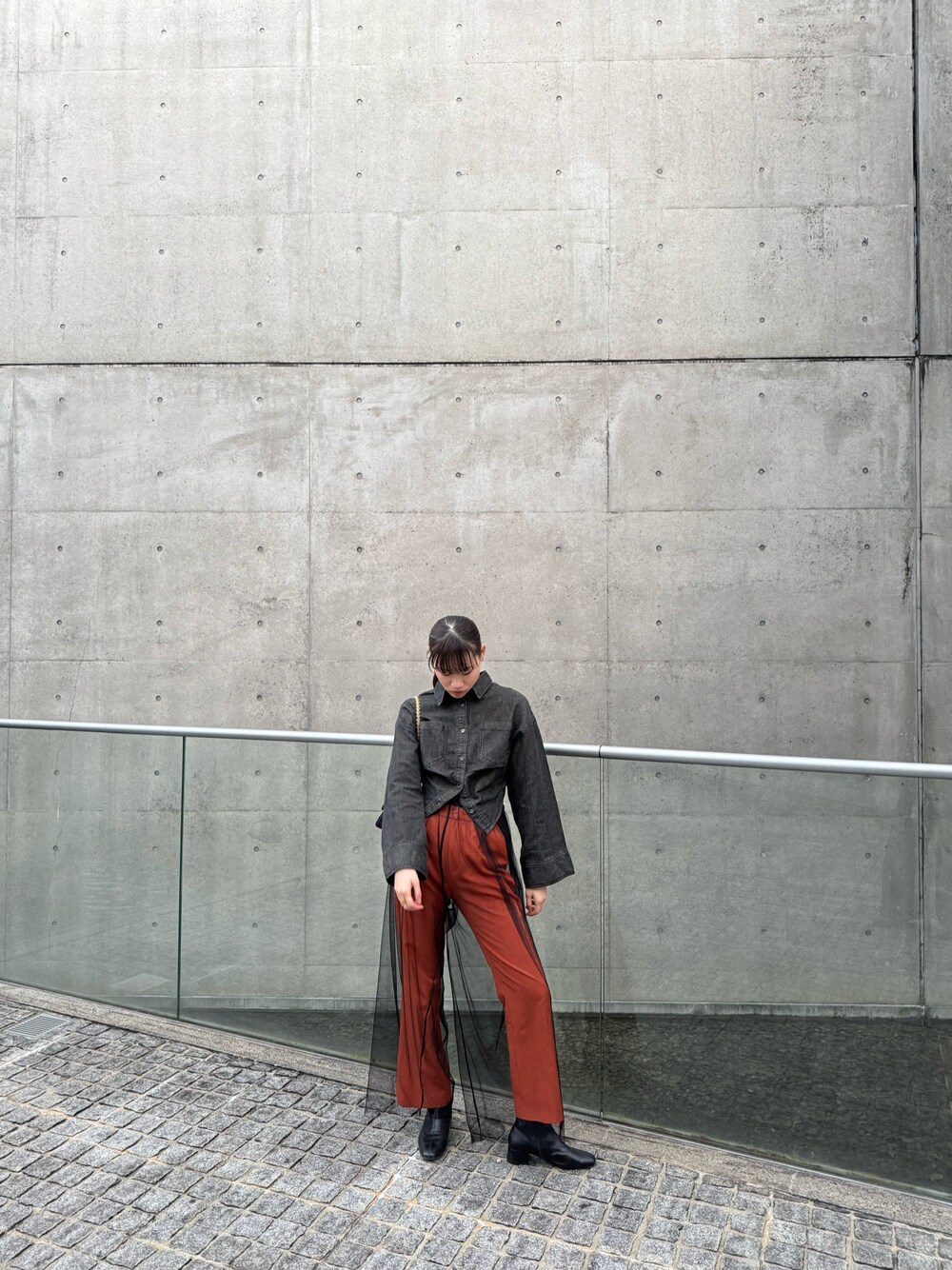 オレンジ系のその他パンツ、ブラック系のシャツ/ブラウス、ブラック系のその他パンツを着用したレディースの冬コーディネートの1枚目の写真