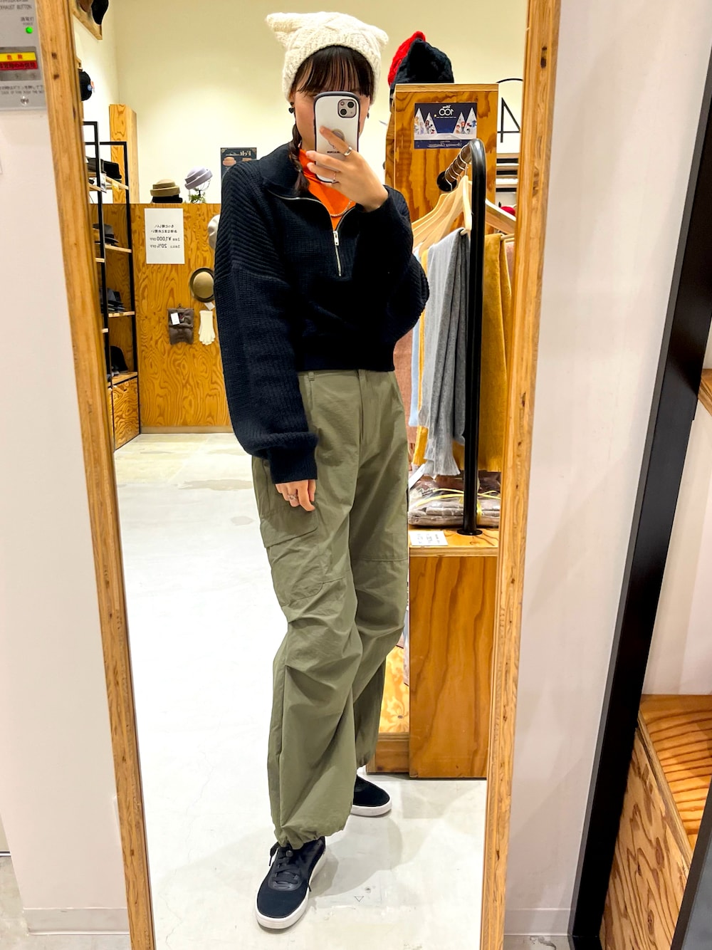 ブラック系のニット/セーター、グリーン系のカーゴパンツ、ブラック系のスニーカーを着用したレディースの秋コーディネートの1枚目の写真