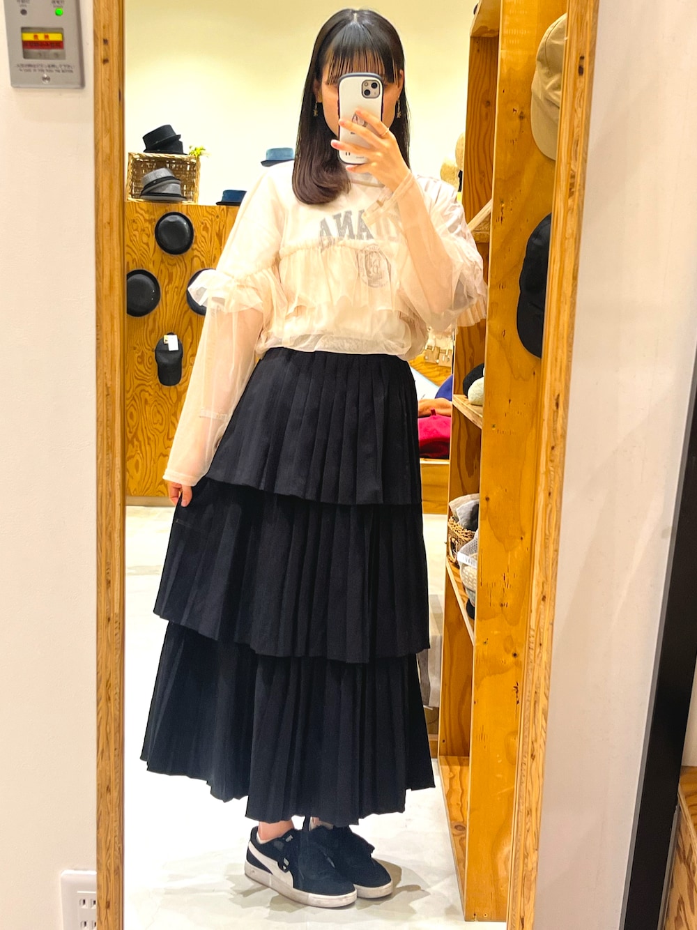 ブラック系のスニーカー、ブラック系のスカート、ベージュ系のTシャツ/カットソーを着用したレディースの春コーディネートの1枚目の写真