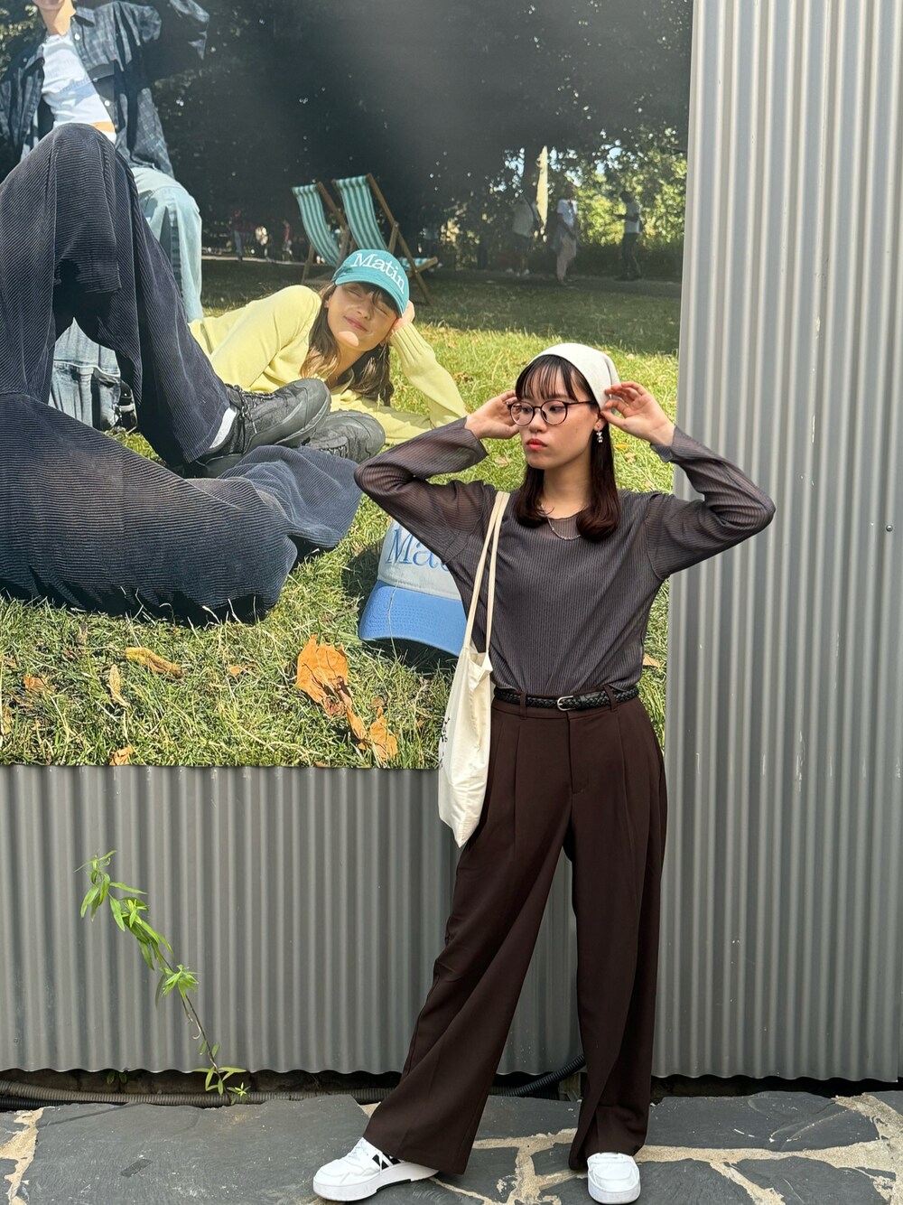 ブラウン系のパンツ、グレー系のシャツ/ブラウス、ホワイト系のスニーカーを着用したレディースの秋コーディネートの1枚目の写真