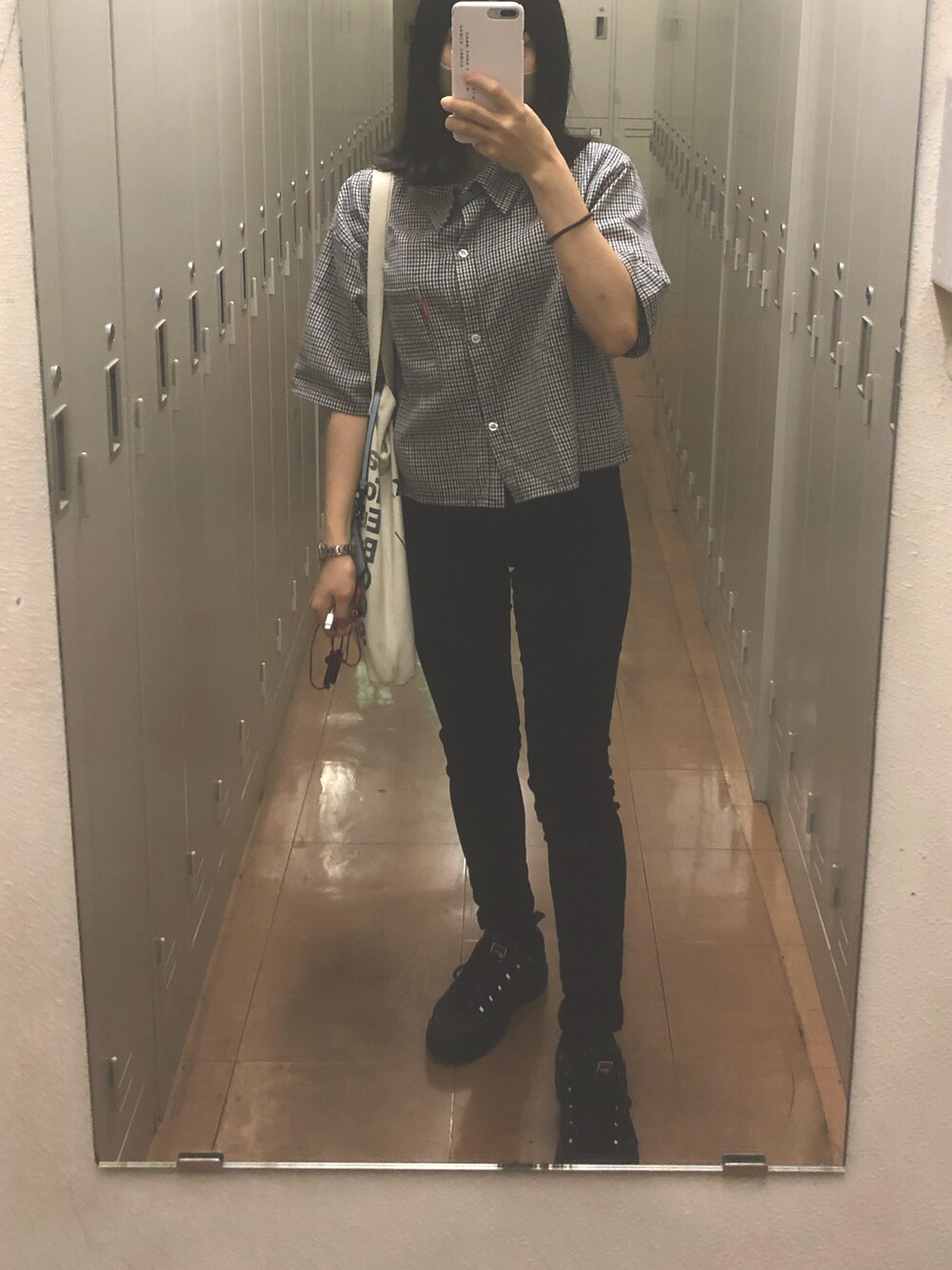 ブラック系のスニーカー、ブラック系のデニムパンツ、ブラック系のシャツ/ブラウスを着用したレディースの秋コーディネートの1枚目の写真