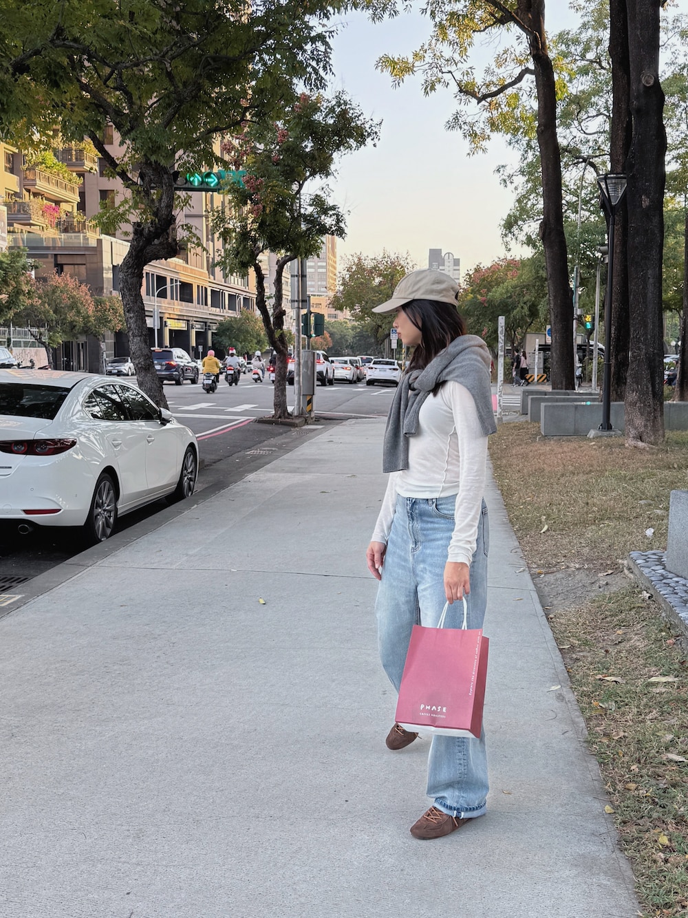 ブルー系のデニムパンツ、ブラウン系のシューズ、ホワイト系のTシャツ/カットソーを着用したレディースの秋コーディネートの1枚目の写真