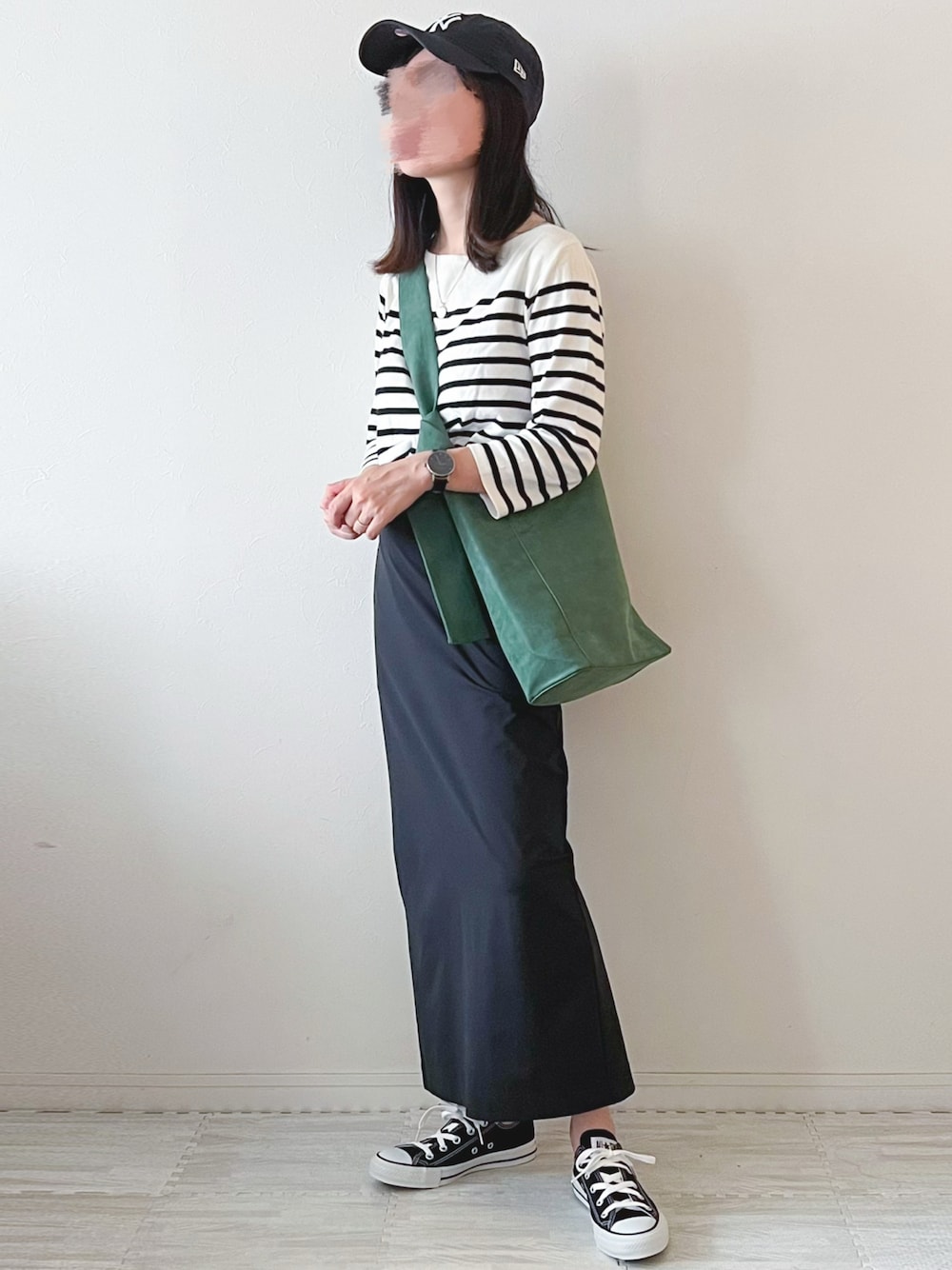 ブラック系のスカート、オレンジ系のショルダーバッグ、ホワイト系のTシャツ/カットソーを着用したレディースの秋コーディネートの1枚目の写真