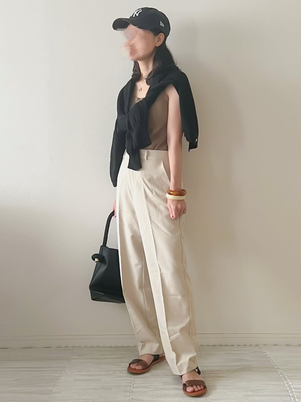 ブラウン系のタンクトップ、ホワイト系のその他パンツ、ブラック系のハンドバッグを着用したレディースの夏コーディネートの1枚目の写真