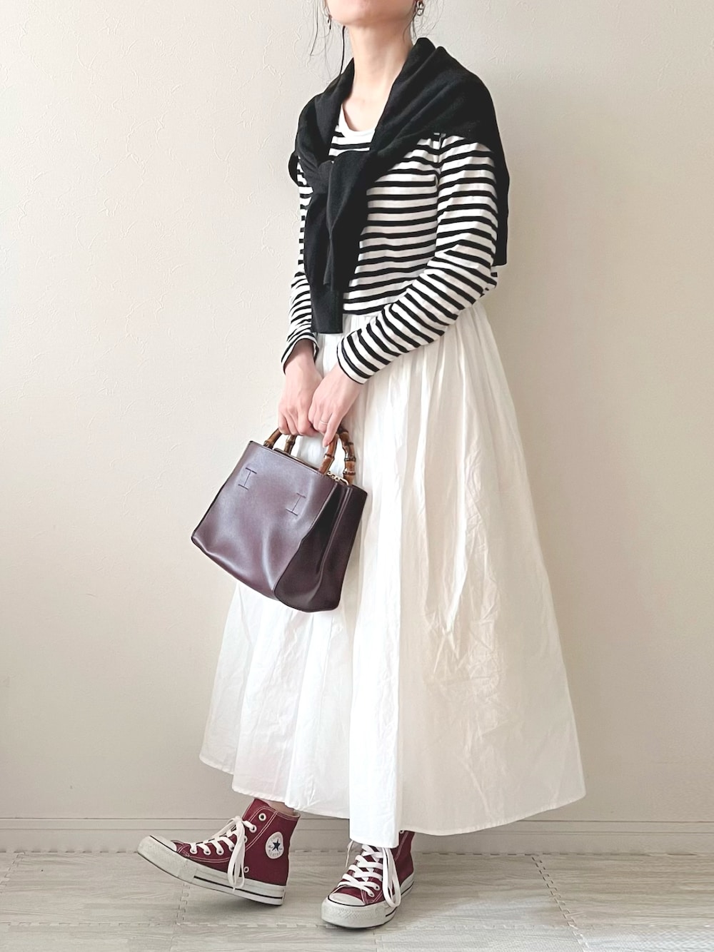 ホワイト系のスカート、パープル系のハンドバッグ、レッド系のスニーカーを着用したレディースの春コーディネートの1枚目の写真