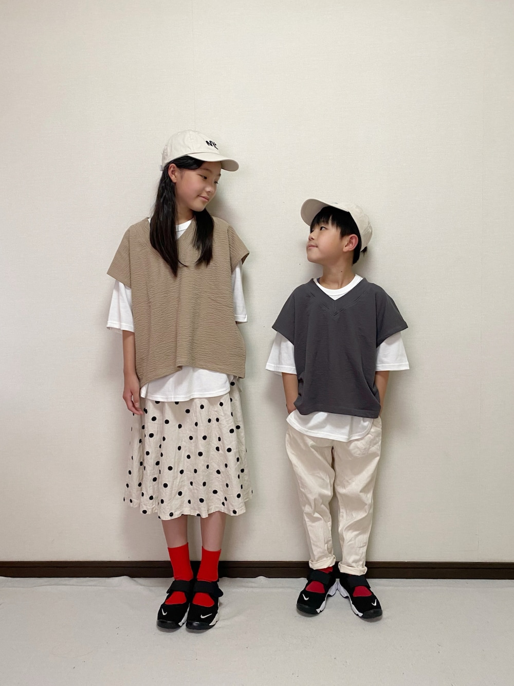 ベージュ系のトップス、グレー系のトップス、ホワイト系のスカートを着用したキッズの春コーディネートの1枚目の写真