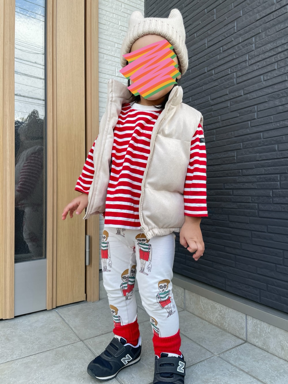 レッド系のTシャツ/カットソー、ベージュ系のダウンベスト、ホワイト系のその他パンツを着用したレディースの冬コーディネートの1枚目の写真