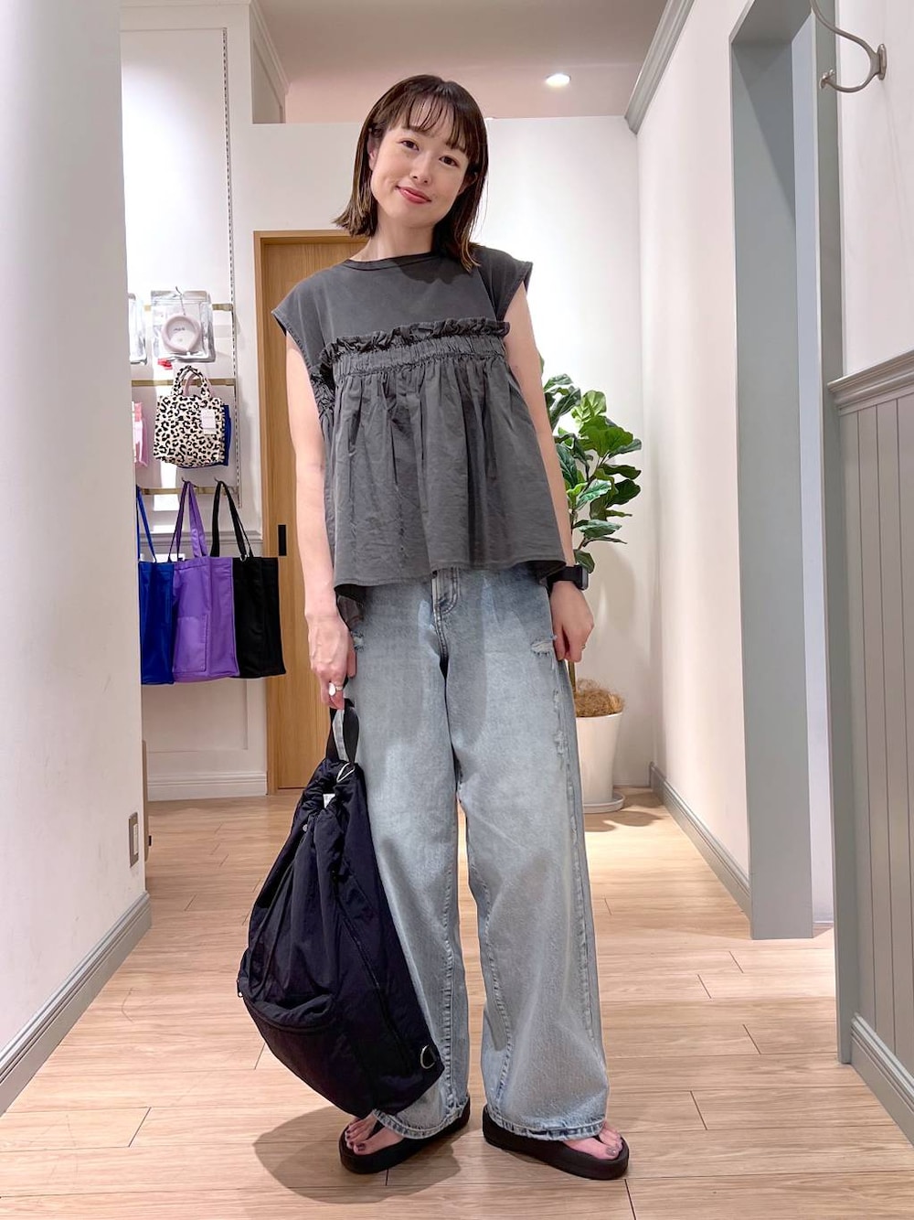 ブラック系のショルダーバッグ、ブルー系のデニムパンツ、グレー系のTシャツ/カットソーを着用したレディースの夏コーディネートの1枚目の写真