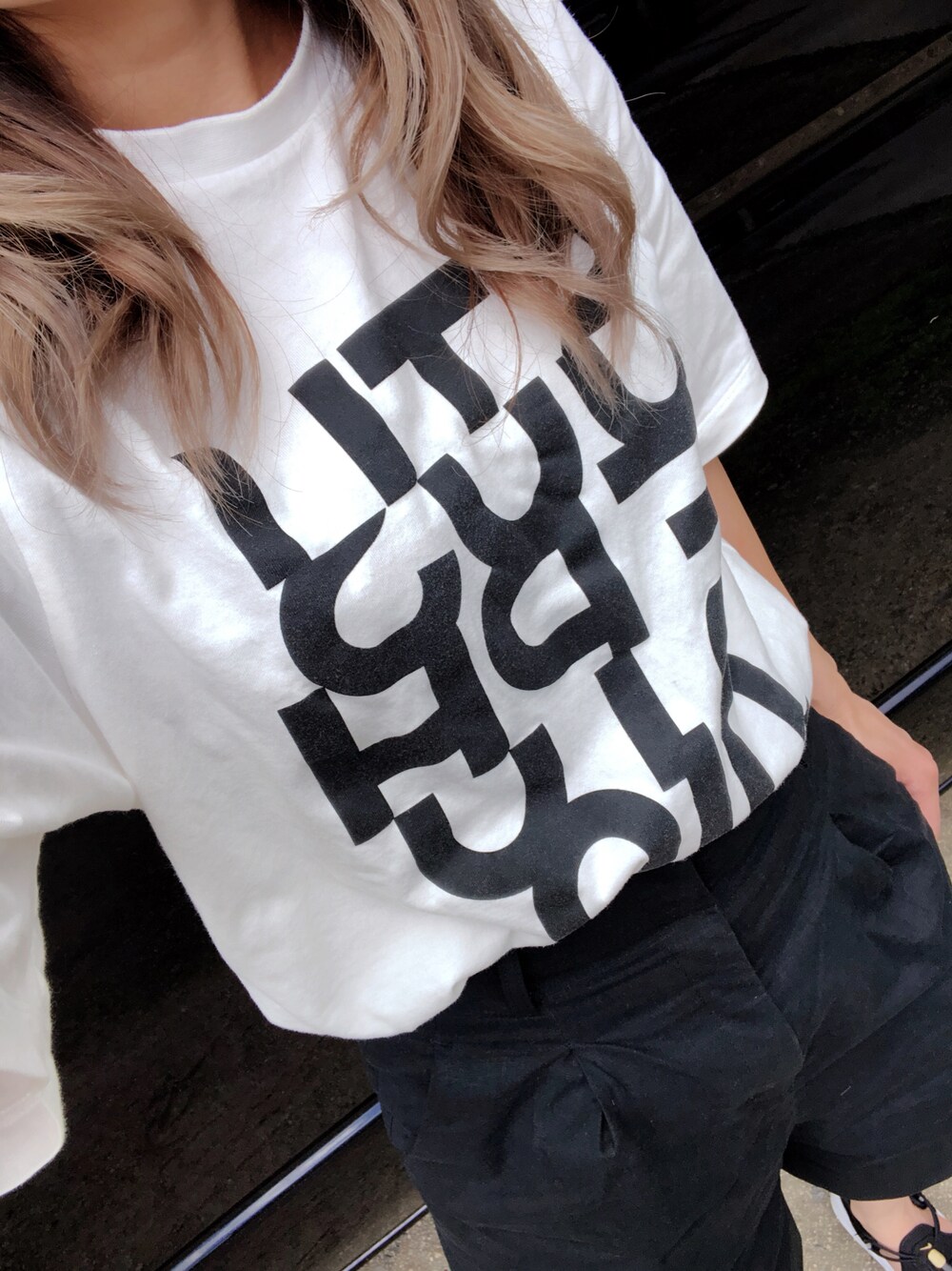 ホワイト系のTシャツ/カットソー、ブラック系のその他パンツ、ブラック系のサンダルを着用したレディースの秋コーディネートの1枚目の写真