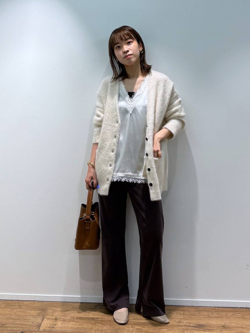 ホワイト系のシャツ/ブラウス、ベージュ系のカーディガン/ボレロ、ブラウン系のショルダーバッグを着用したレディースの秋コーディネートの1枚目の写真